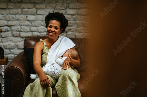 Smiling woman breastfeeding her baby