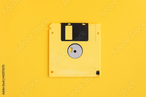 Yellow floppy diskette on yellow background.