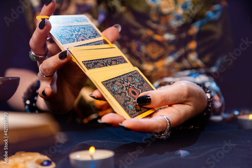 Esotiricism. The witch shuffles the tarot cards in her hands. Close-up. The concept of witchcraft and divination