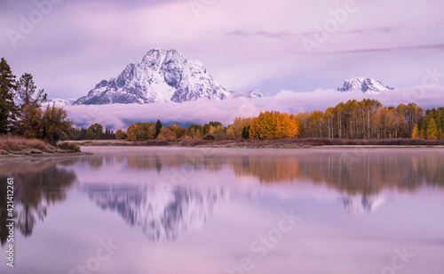Wintry weather in autumn at sunrise..Captivating view of Mt . Moran as it reflects its alpine peak in Snake River in Grand Teton National park , Wyoming.
