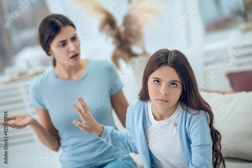 Daughter with grimace unwilling of listening to talking mom