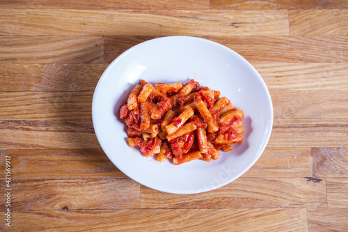 Rigatoni paste in tomato sauce with onion and vegetable. Red sos Penne pasta. Fresh food. Fres italian dish. Italian kitchen.