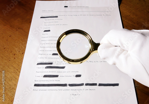 A spy looking at a (fake) secret document with a magnifying lens. 