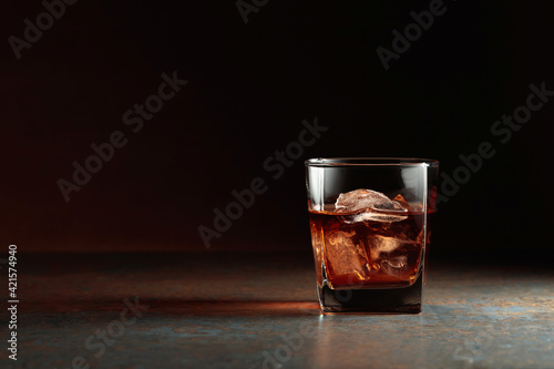 Glass of whiskey on a rusty background.