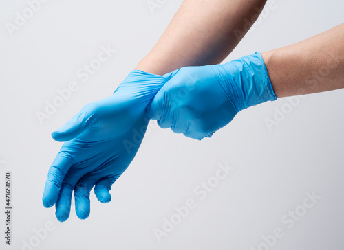 Two hands wearing nitrile gloves on a white background