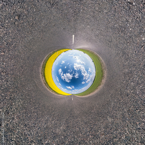 blue sky ball in middle of swirling asphalt road or field. Inversion of tiny planet transformation of spherical panorama 360 degrees. Spherical abstract view. Curvature of space.