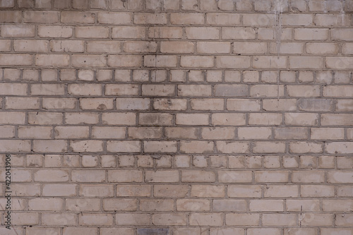 A white old brick wall, darkened with age. texture