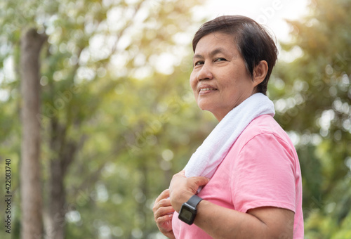 Portrait of Asian Senior woman smiling while doing exercise workout at park outdoor