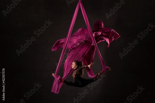 Woman performing acrobatic dance on aerial silks