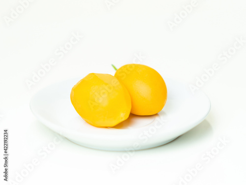 The peeled marian plum is placed in a white plate.