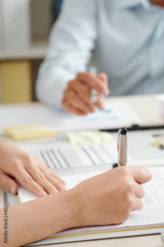 Close-up image of businesswoman or lawyer proofreading contract and correcting important details