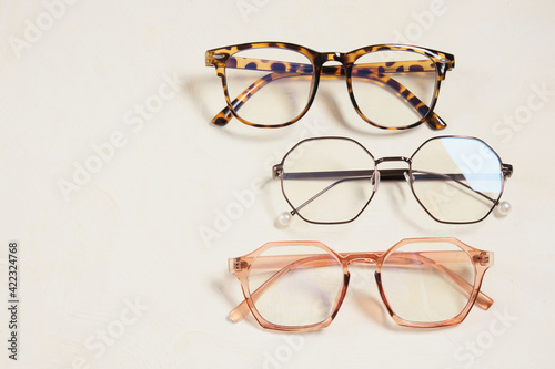 several fashionable stylish glasses on a beige background place copy top view, optics store