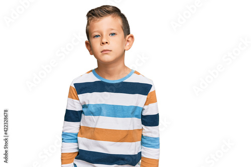Adorable caucasian kid wearing casual clothes with serious expression on face. simple and natural looking at the camera.