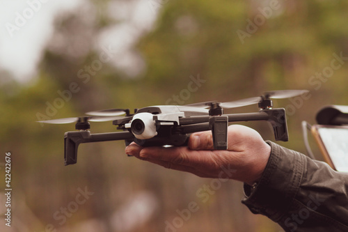 Man hands close-up holding drone remote control and cell phone. Electronic technology and safety concept.