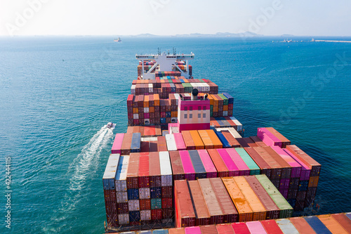 Rear view cargo container ship. Business logistic transportation sea freight,Cargo ship, Cargo container in factory harbor at industrial estate for import export around in the world, Trade Port.