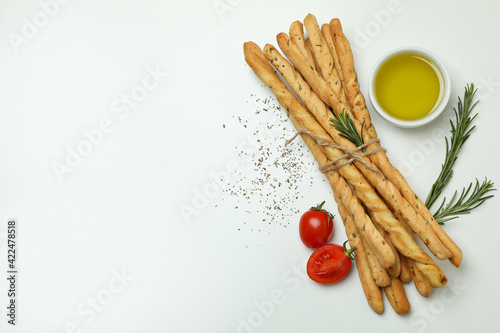 Grissini breadsticks with spices on white background