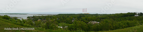 Super wide panoramic view of a coastal community along the shore with industrial smoke stacks from power plant in background