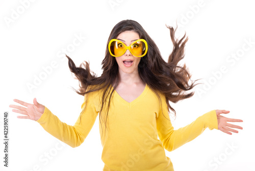 Happy smiling excited comical surprised young attractive woman with long flying hair and big funny glasses over white background.
