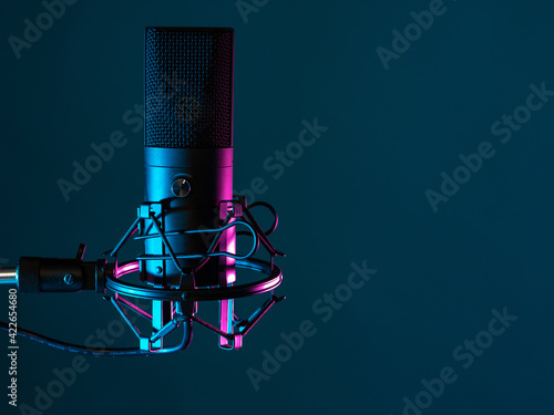 Professional studio microphone. Condenser microphone on a dark background. It is designed for podcasting. Microphone as a symbol for recording audio podcasts. Recording audio podcasts in studio