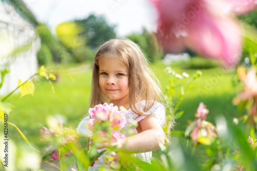 happy child girl with flowers in the countryside