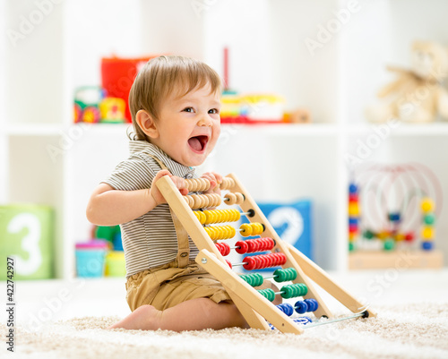 Little child boy playing with toy blocks. Baby in nursery or kindergarten