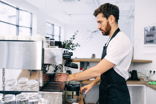 A professional, experienced barista prepares coffee in a coffee