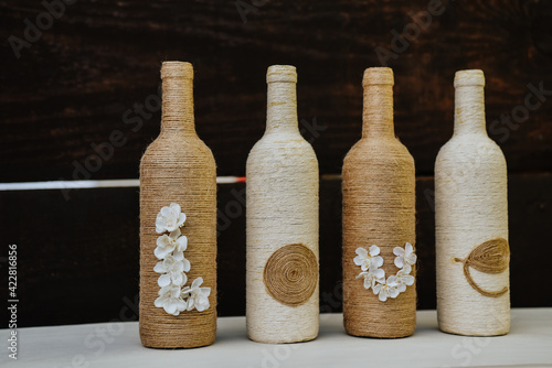 Row of bottle crafts wrapped with jute twine with the word LOVE- beautiful rustic decoration