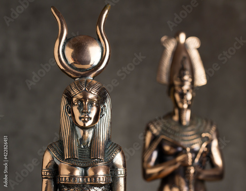 Egyptian goddess Isis with Tutankhamen on a brown background.