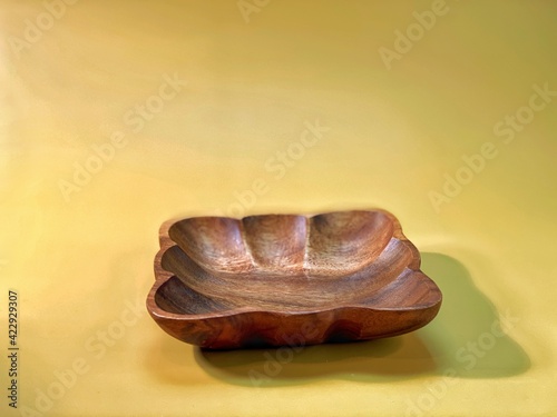 brown wooden bowls lie on the yellow background