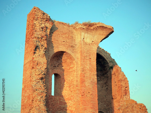 Ruins of an ancient medieval cathedral illuminated by the setting sun. Complementary colors during twilight.