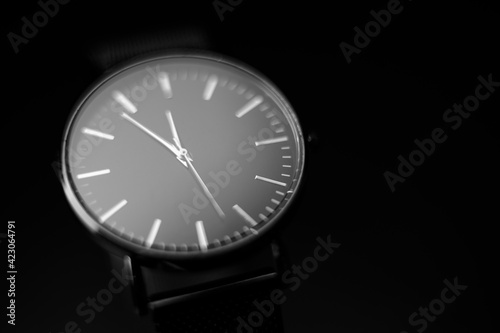 black modern analog wristwatch on a black background