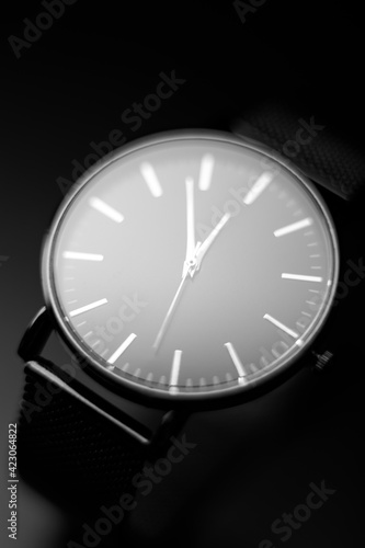 black modern analog wristwatch on a black background