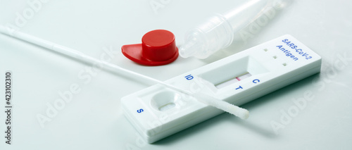 Rapid antigen self test kit with negative result, covid-19 diagnostic with nasal swabs, tube and detection device, light background, copy space, panoramic format