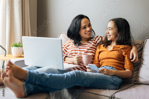 Single mother working from home with preteen daughter around