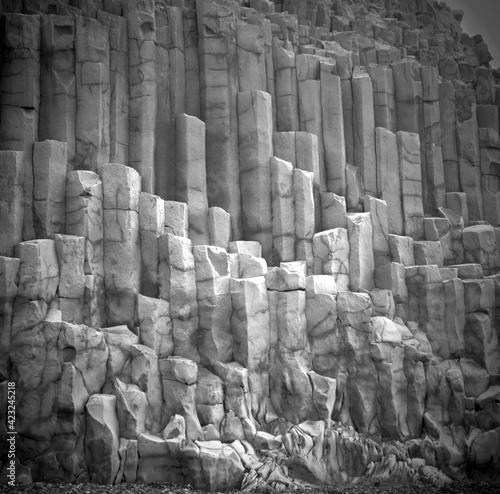 Unique natural basalt rock pillars columns in Iceland. Geological wonder hexagonal volcanic formations in Vik beach.