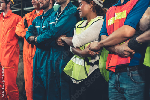 Skillful worker stand together showing teamwork in the factory . Industrial people and manufacturing labor concept .