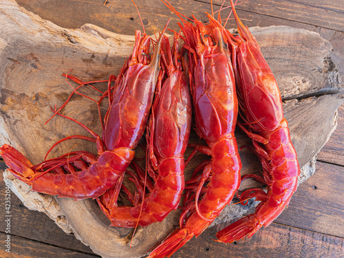 Fresh raw giant red carabineros prawns on a wooden board