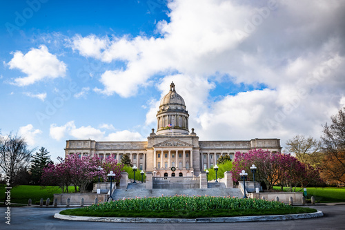 Frontal view of the Kentucky Capitol Building in the state capital of Frankfort with flowers of a roundabout on the foreground