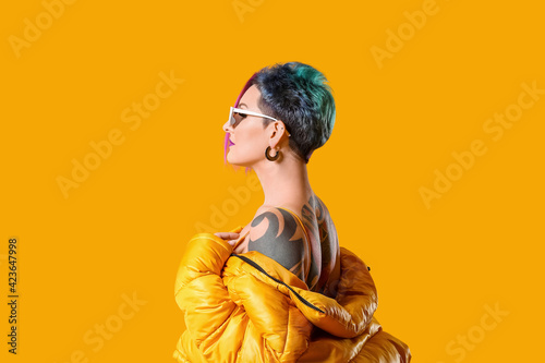 Portrait of extravagant stylish woman on color background