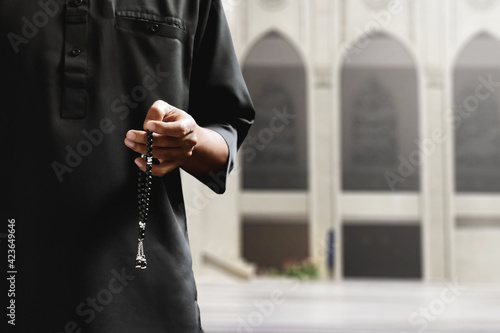 Religious asian muslim man holding rosary beads