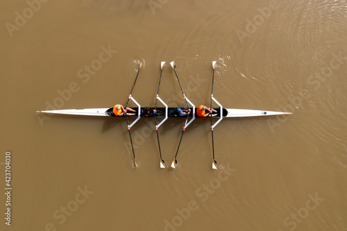 Sport Canoe with a team of four people rowing on tranquil water, Aerial view.