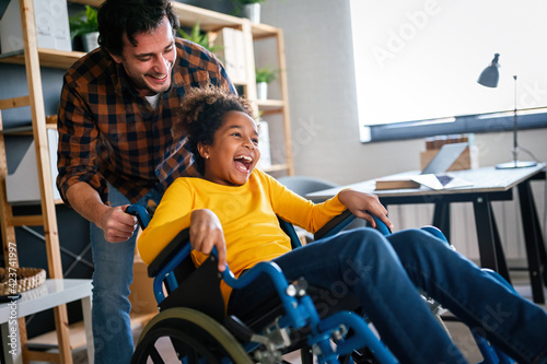 Multiethnic happy family activities with disabled handicapped child in wheelchair