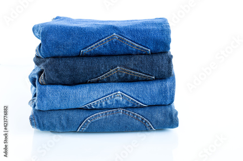 stack of blue jeans on a white background