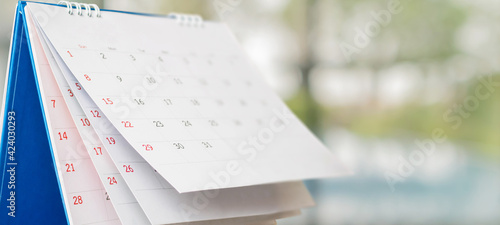 Close up white paper desk calendar with blurred bokeh background appointment and business meeting concept