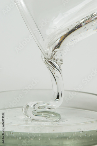 Macro shot of glue or streaming light transparent liquid