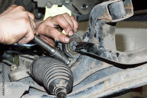 The mechanic tightens the stabilizer bushing mount