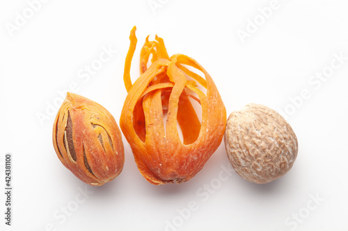 Macro close-up of Organic mace with nutmeg seed (Myristica fragrans) on white background. Pile of Indian Aromatic Spice. Top view