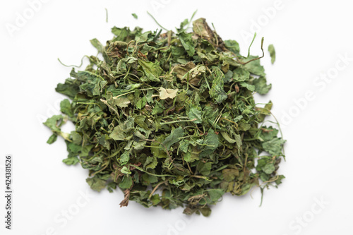 Macro close-up of Organic green dry Fenugreek leaves (Trigonella foenum-graecum) on white background. Pile of Indian Aromatic Spice. Top view