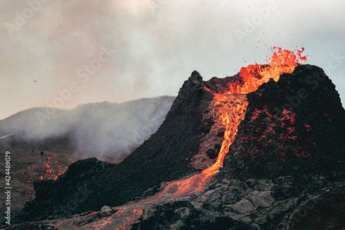 Volcanic eruption in Iceland, lava bursting from the volcano. Bright red magma.