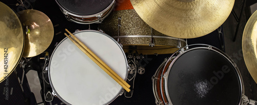 Musical instruments close up banner. Beautiful snare drum and hi-hat cymbals with drummer holding drumsticks. Modern drum set. Music shop.